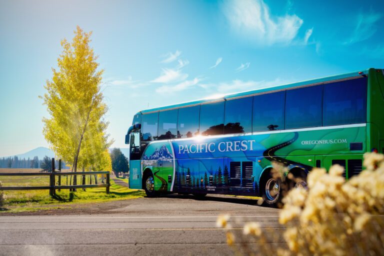 PCBL Bus pulling into a beautiful ranch with fall color trees in the background