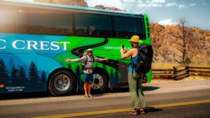 PCT travelers taking a picture in front of a Pacific Crest Bus Lines Bus wrap