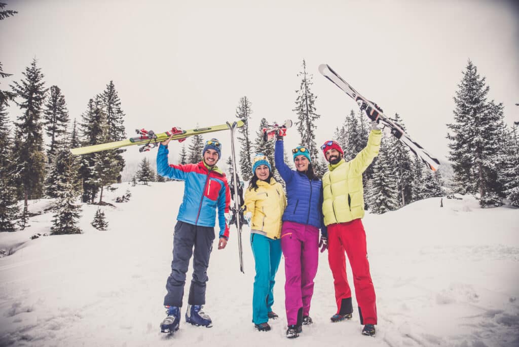4 skiers posing for the camera holding up their skies