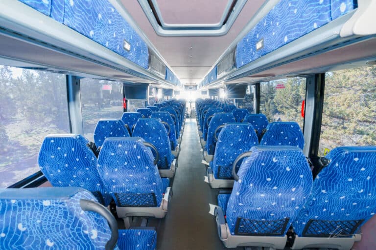 Interior of large Pacific Crest Charter Bus seats and window view from the back looking front
