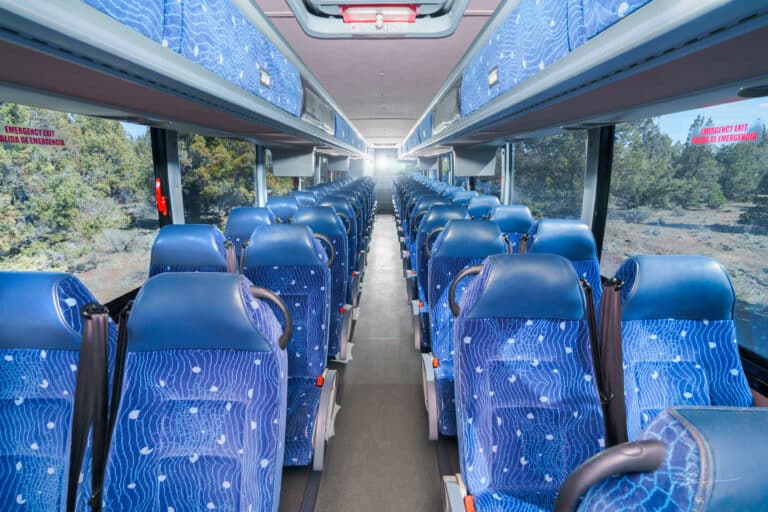 Interior of large Pacific Crest Charter Bus seats and window view from t front looking back